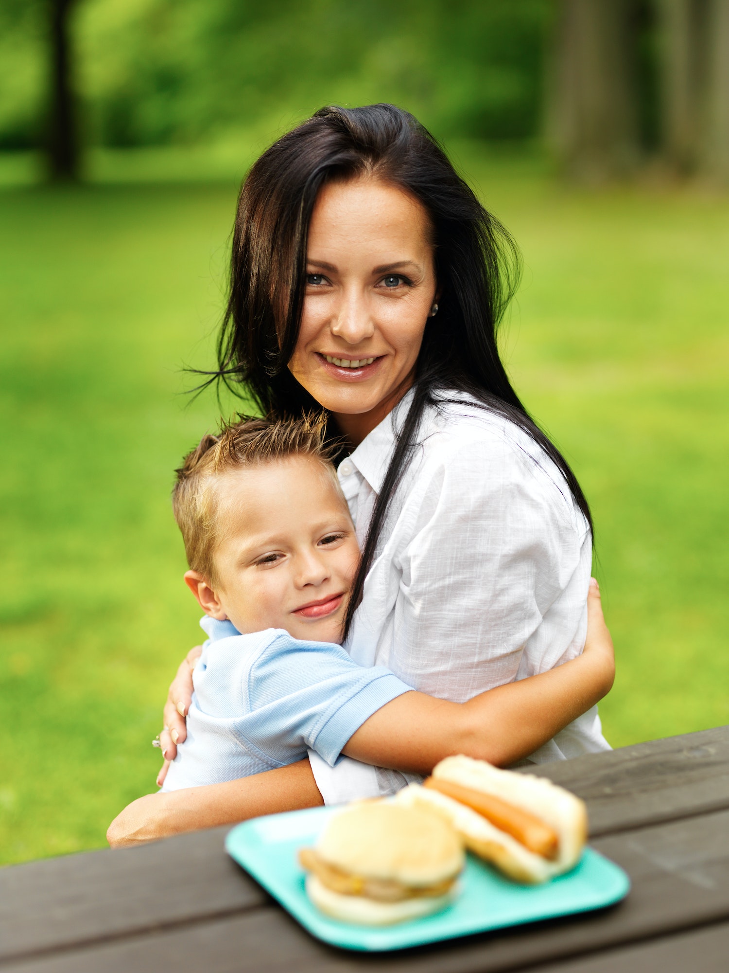 mom and son hugging at picnic table